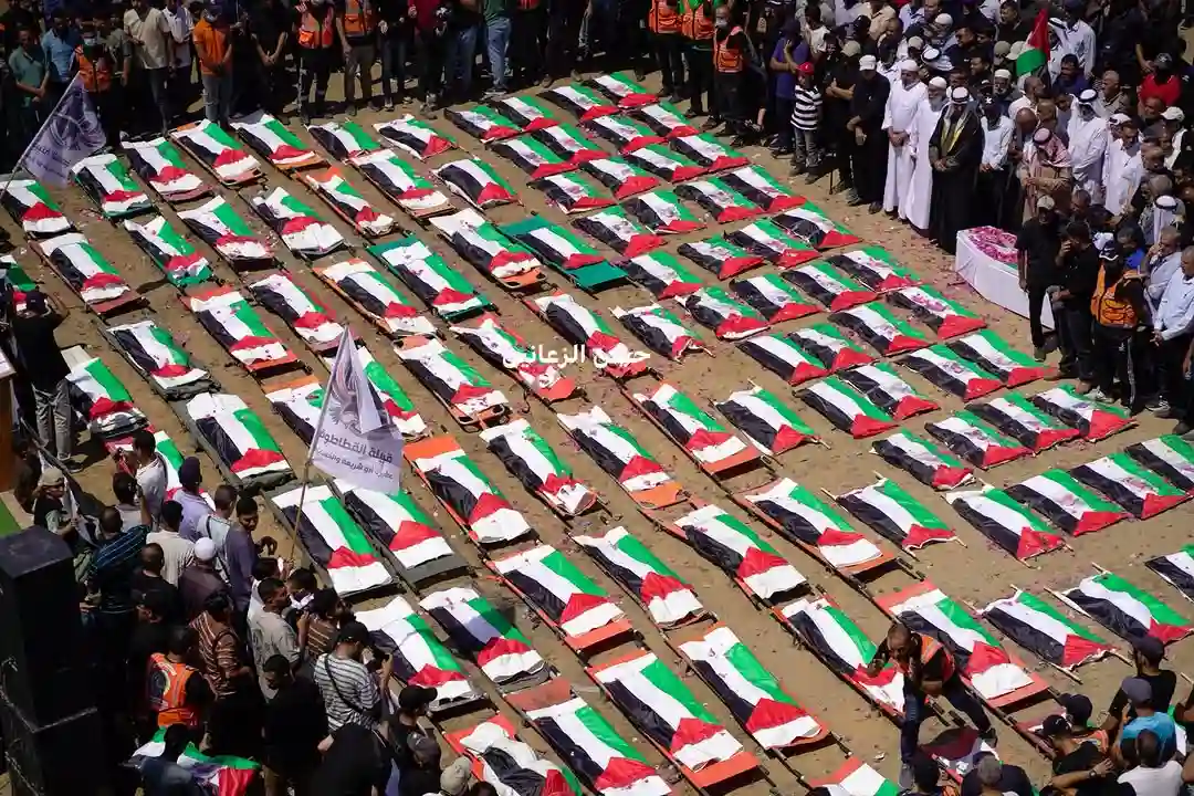 Corpos de 112 palestinos, cobertos por bandeiras, são alinhados durante funeral coletivo na Cidade de Gaza, em 4 de agosto de 2026, após serem retirados dos escombros de um ataque de 2023.