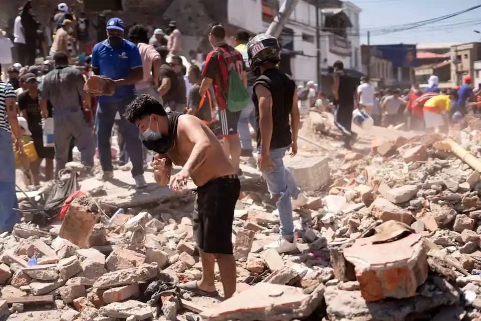 Moradores procuram entre os escombros de um prédio destruído pelo terremoto em Cali, na Colômbia, em 10 de agosto de 2026.